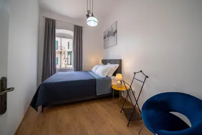 a bedroom with a bed and a blue chair at Main Square View in Kotor