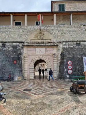 people walking through an archway in a castle at Main Square View in Kotor
