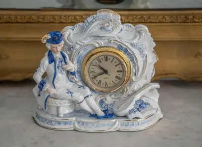 a white and gold clock sitting next to a table at Main Square View in Kotor