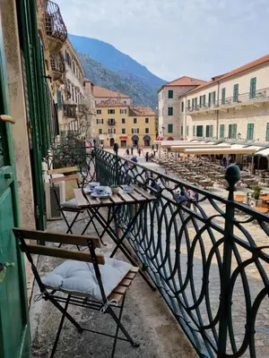 a balcony with tables and chairs on a city street at Main Square View in Kotor