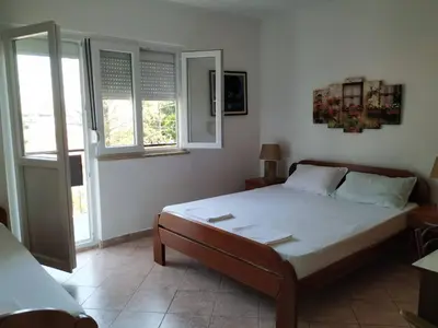 a bedroom with a bed and two windows at Apartman Nadja - Sutomore in Sutomore