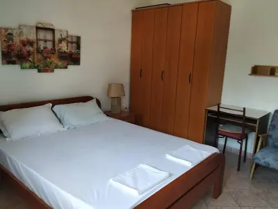 a bedroom with a bed and a cabinet and a chair at Apartman Nadja - Sutomore in Sutomore