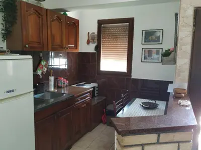 a kitchen with wooden cabinets and a counter top at Apartman Nadja - Sutomore in Sutomore