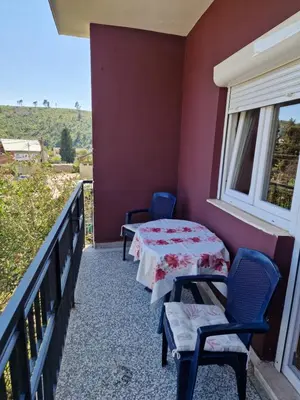 a balcony with two tables and chairs and a window at Apartman Nadja - Sutomore in Sutomore