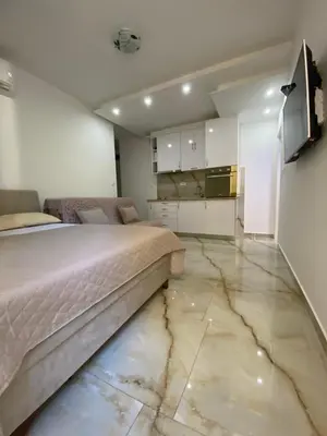 a bedroom with a bed and a marble floor at Apartman Nora in Rafailovici