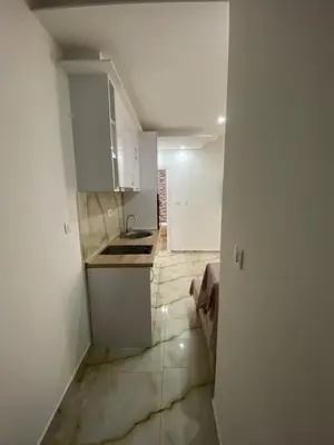 a small kitchen with white cabinets and a sink at Apartman Nora in Rafailovici