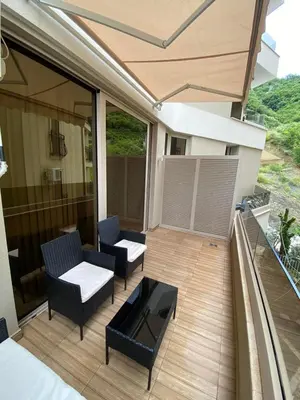a patio with chairs and a table on a balcony at Apartman Nora in Rafailovici