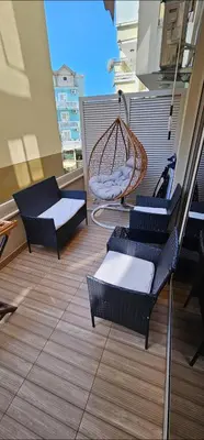 a balcony with chairs and a hammock on a building at Apartman Nora in Rafailovici