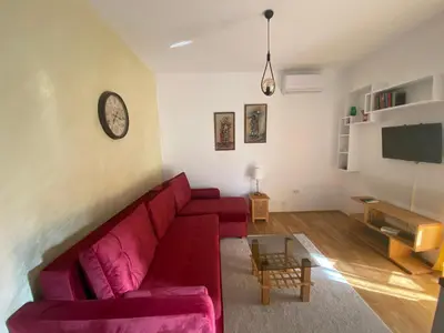 a living room with a red couch and a tv at Studio Z in Podgorica