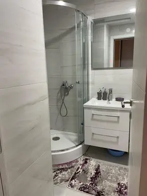 a white bathroom with a shower and a sink at Apartman DVA SRCA in Bar