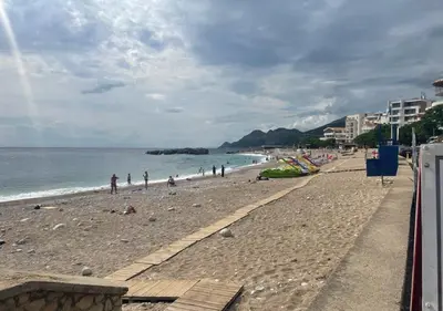 a beach with a group of people and the ocean at Apartment SuSe in Dobra Voda