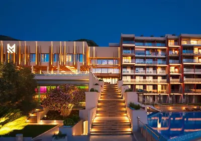 a view of a building with a swimming pool at night at Maestral Resort & Casino in Budva