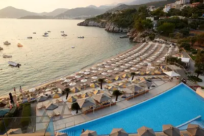 an aerial view of a beach with umbrellas and a swimming pool at Maestral Resort & Casino in Budva