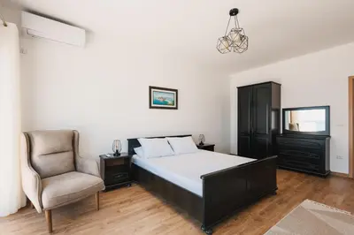 a bedroom with a bed and a chair at Seafront Villa with Private Pool in Dobra Voda, Montenegro in Bar