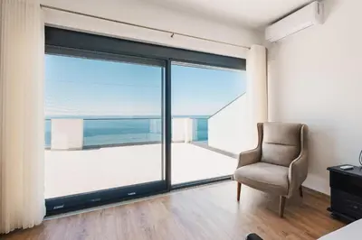 a room with a chair and a large window at Seafront Villa with Private Pool in Dobra Voda, Montenegro in Bar