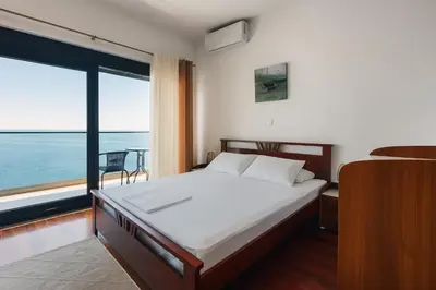 a bedroom with a bed with a view of the ocean at Seafront Villa with Private Pool in Dobra Voda, Montenegro in Bar