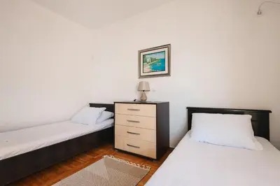 a bedroom with two beds and a dresser in it at Seafront Villa with Private Pool in Dobra Voda, Montenegro in Bar