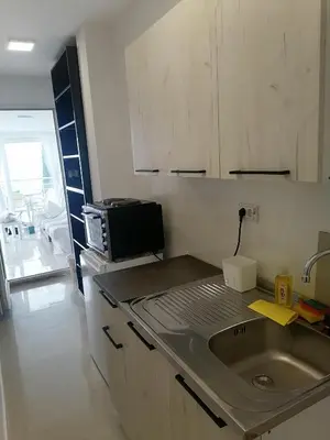 a kitchen with a sink and a microwave at One minute to the beach in Becici