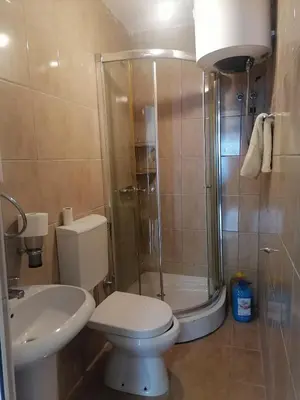a bathroom with a shower and a toilet and a sink at One minute to the beach in Becici