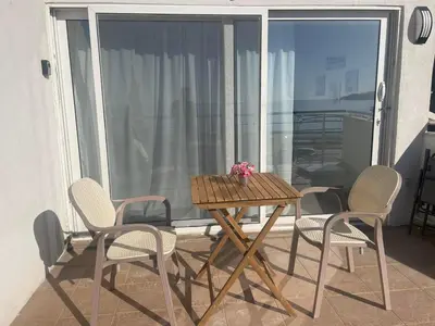 a wooden table and four chairs on a balcony at One minute to the beach in Becici