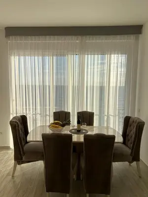 a dining room table and chairs with a large window at Paradise beachfront view 2 in Dobra Voda