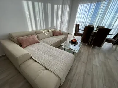 a living room with a white couch and a table at Paradise beachfront view 2 in Dobra Voda