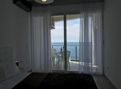 a bedroom with a bed and a view of the ocean at Paradise beachfront view 2 in Dobra Voda