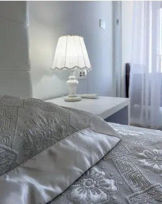 a bed with a pillow and a lamp on a table at Paradise beachfront view 2 in Dobra Voda