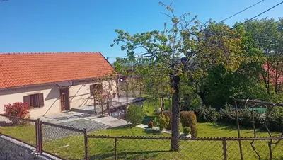 a house with a fence in front of a yard at Holiday in the National park Lovcen in Cetinje