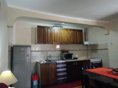 a kitchen with wooden cabinets and a microwave at Holiday in the National park Lovcen in Cetinje
