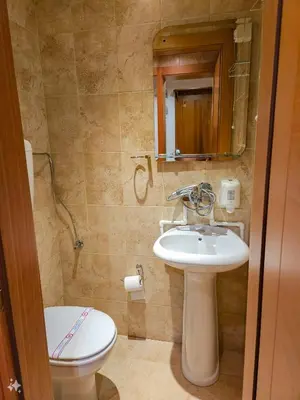 a bathroom with a sink and a toilet and a mirror at Mali Hotel BaMBiS in Podgorica