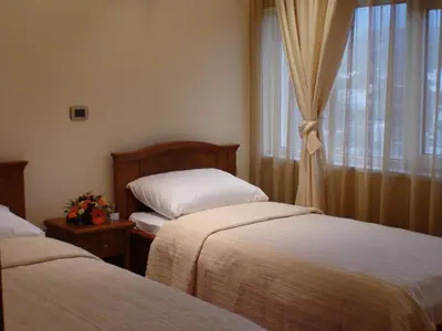 a hotel room with two beds and a window at Mali Hotel BaMBiS in Podgorica