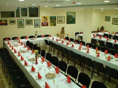 a conference room with long tables and chairs with red cones on them at Mali Hotel BaMBiS in Podgorica