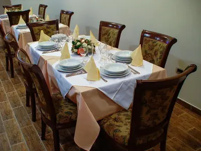a long table with plates and napkins on it at Mali Hotel BaMBiS in Podgorica