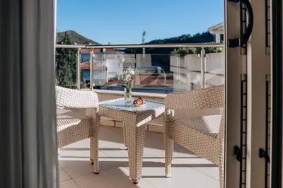 a table and chairs on a balcony with a view at Apartments Del Mar in Petrovac na Moru