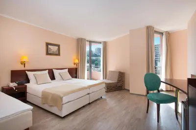 a hotel room with a bed and a table and chair at Iberostar Waves Bellevue All Inclusive in Budva