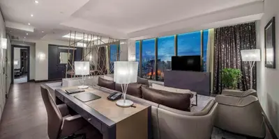 a living room with a couch and a table and a television at Hilton Podgorica Crna Gora in Podgorica