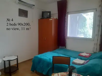 a small bedroom with a bed and a window at OLGA apartmani in Sutomore