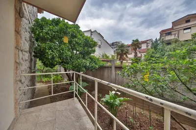 a balcony with a fence and trees and buildings at Markoni Apartments in Budva