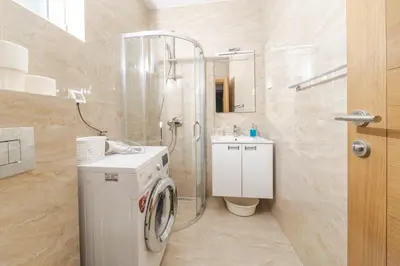 a bathroom with a washing machine and a shower at Markoni Apartments in Budva