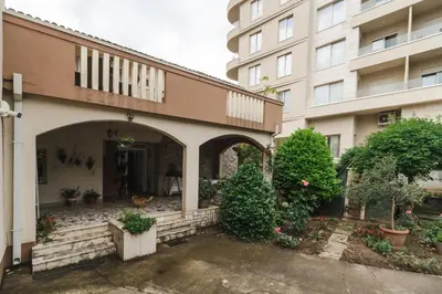 a building with a dog sitting in front of it at Markoni Apartments in Budva