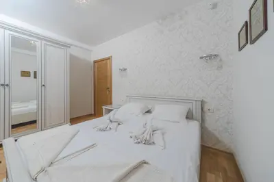 a white bed with white pillows in a bedroom at Markoni Apartments in Budva