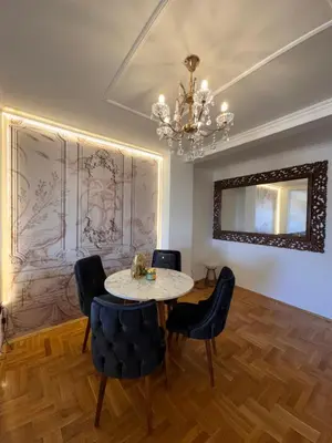 a dining room with a table and chairs and a chandelier at Stan u strogom centru grada in Podgorica