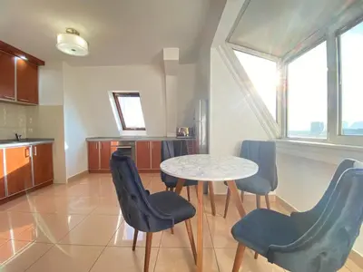 a kitchen with a table and chairs in a room at Stan u strogom centru grada in Podgorica