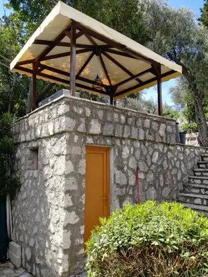 a stone wall with a wooden roof over a door at Villa Golda, The whole house Biker Friendly in Rijeka Reževići