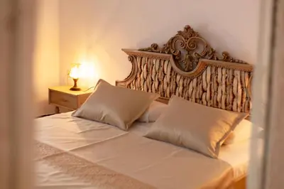 a bedroom with a large bed with a wooden headboard at Casa Antica Druško in Kotor