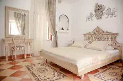 a bedroom with a large bed and a chair at Casa Antica Druško in Kotor