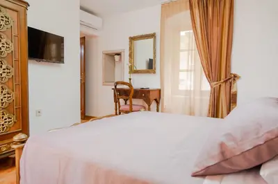 a bedroom with a bed and a desk and a window at Casa Antica Druško in Kotor