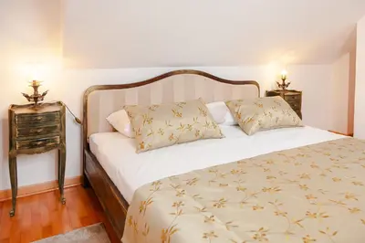 a bedroom with a white bed with two pillows at Casa Antica Druško in Kotor