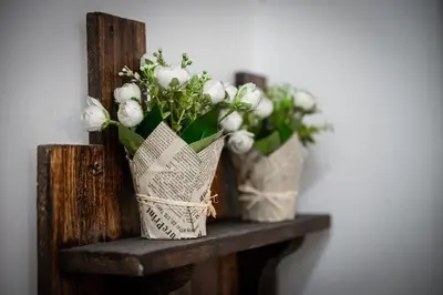 two vases with white flowers sitting on a shelf at Orange Apart in Ulcinj